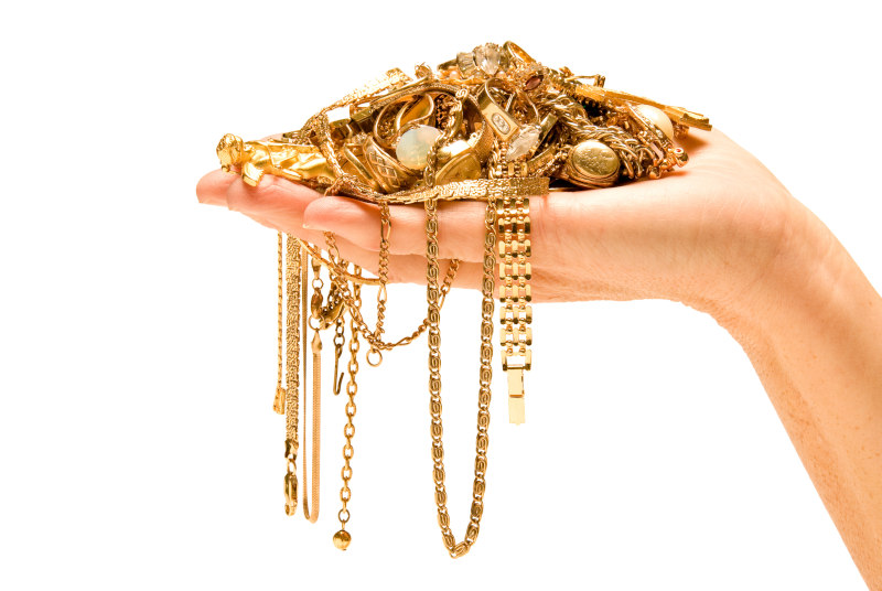 Legierter Goldschmuck mit unterschiedlichem Wert, gehalten von einer Hand